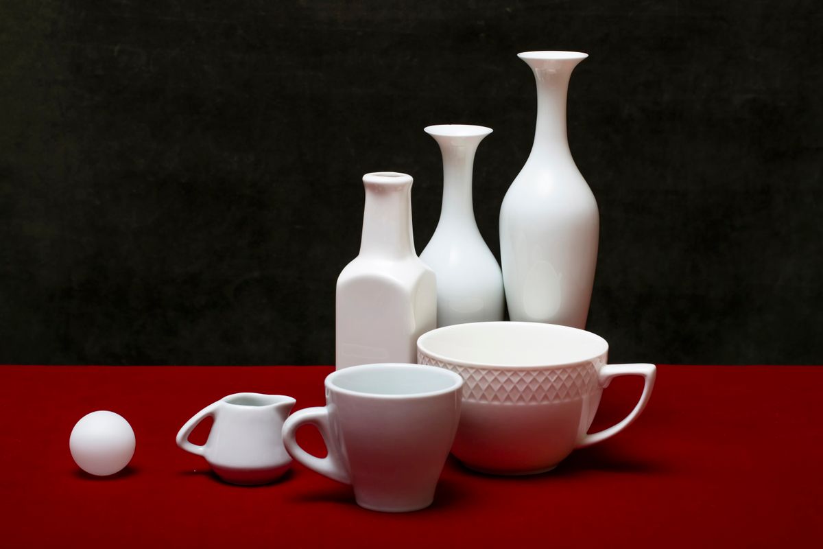 Still life of pottery vase and cups with olive branch