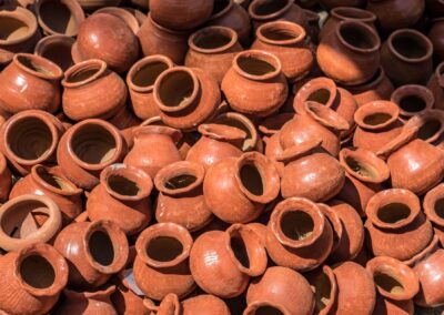 A collection of handmade clay pots displayed in an outdoor market in Mandalay, Myanmar.